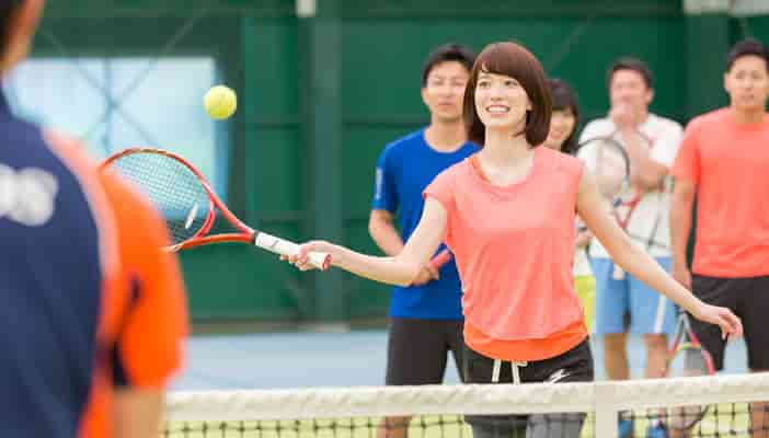 テニススクールでのレッスンをうけている女性